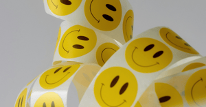 A roll of stickers with smiley faces on them. 