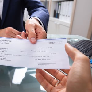 Pay check being passed from employer to employee